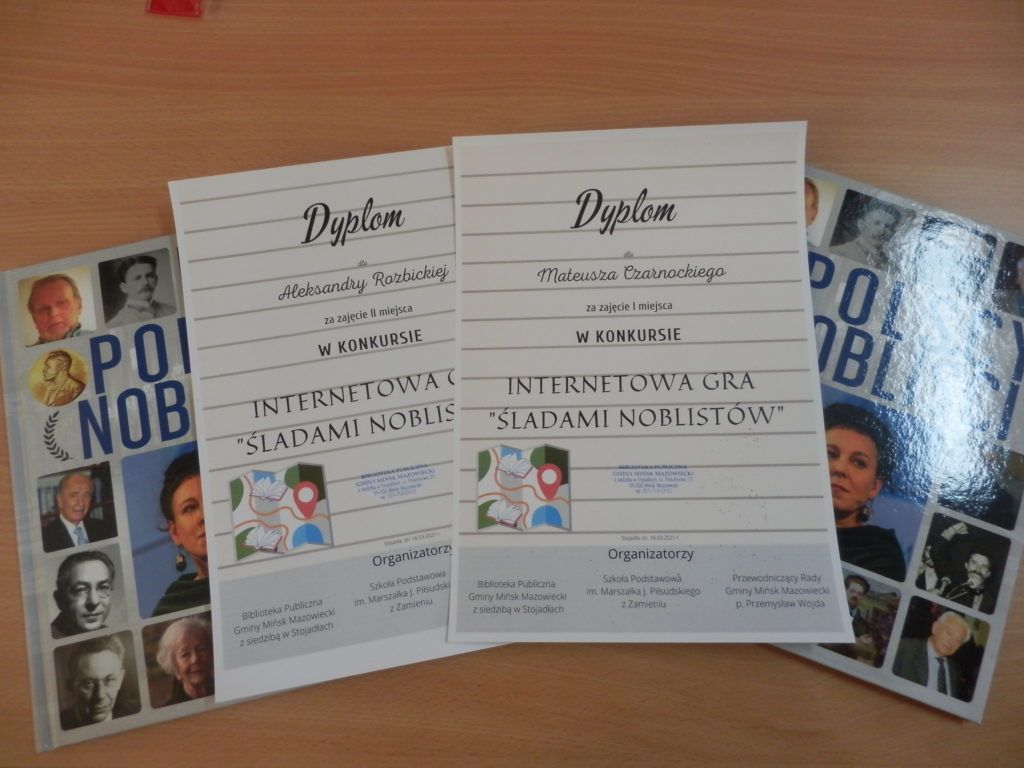zdjęcie przedstawiające dyplomy i nagrody książkowe "Polscy Nobliści" laureatów konkursu Internetowa Gra "Śladami Noblistów"